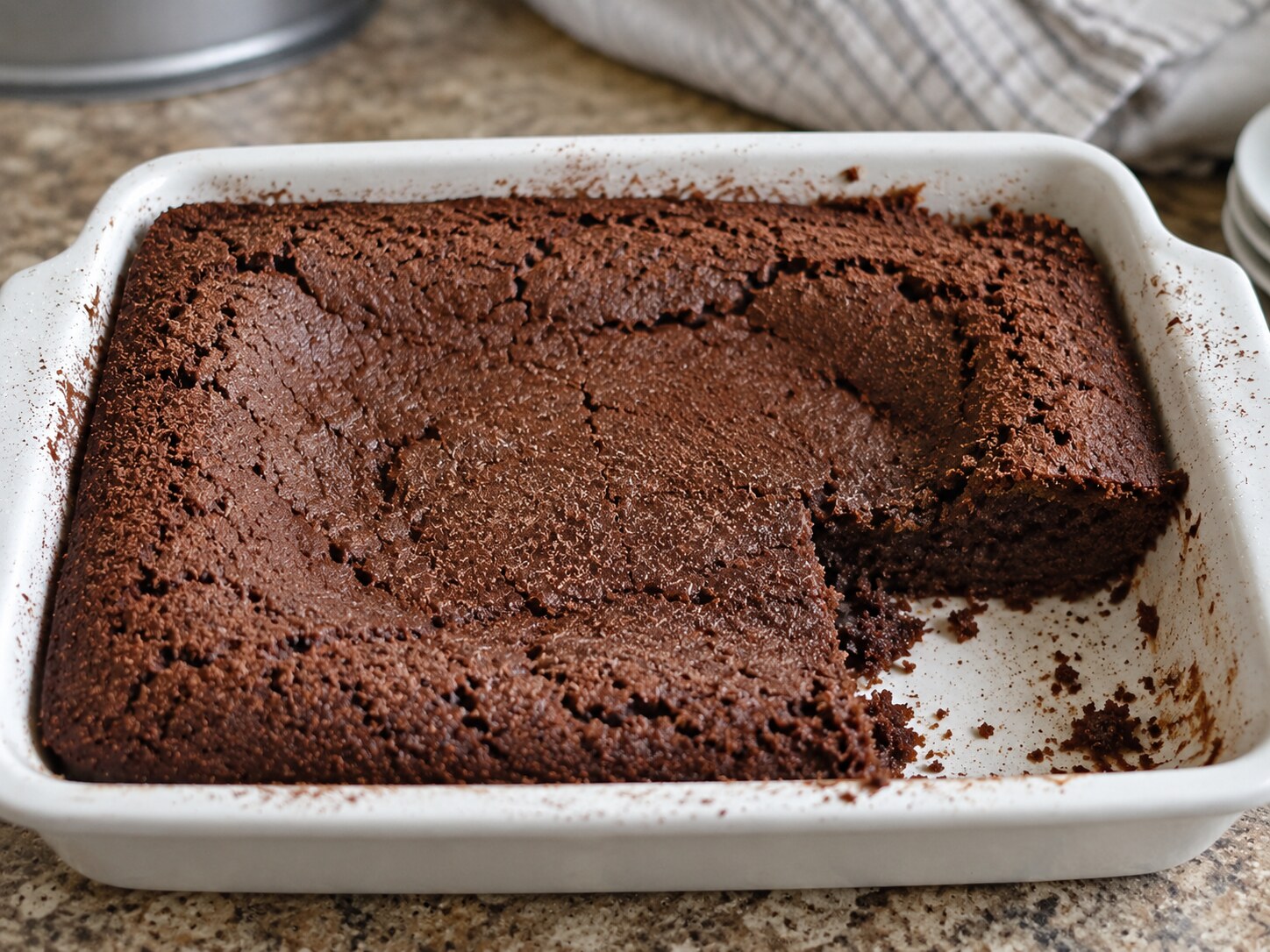 Collapsed cocoa cake with crumbs around a sunken center