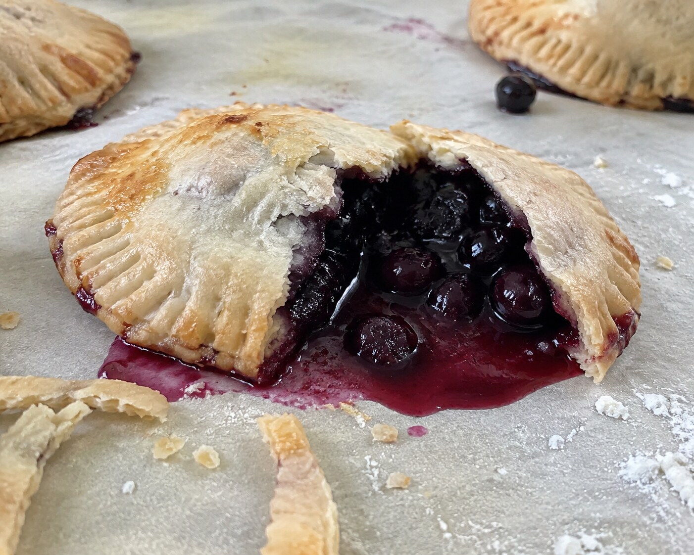 A blueberry hand pie split open with filling spilled
