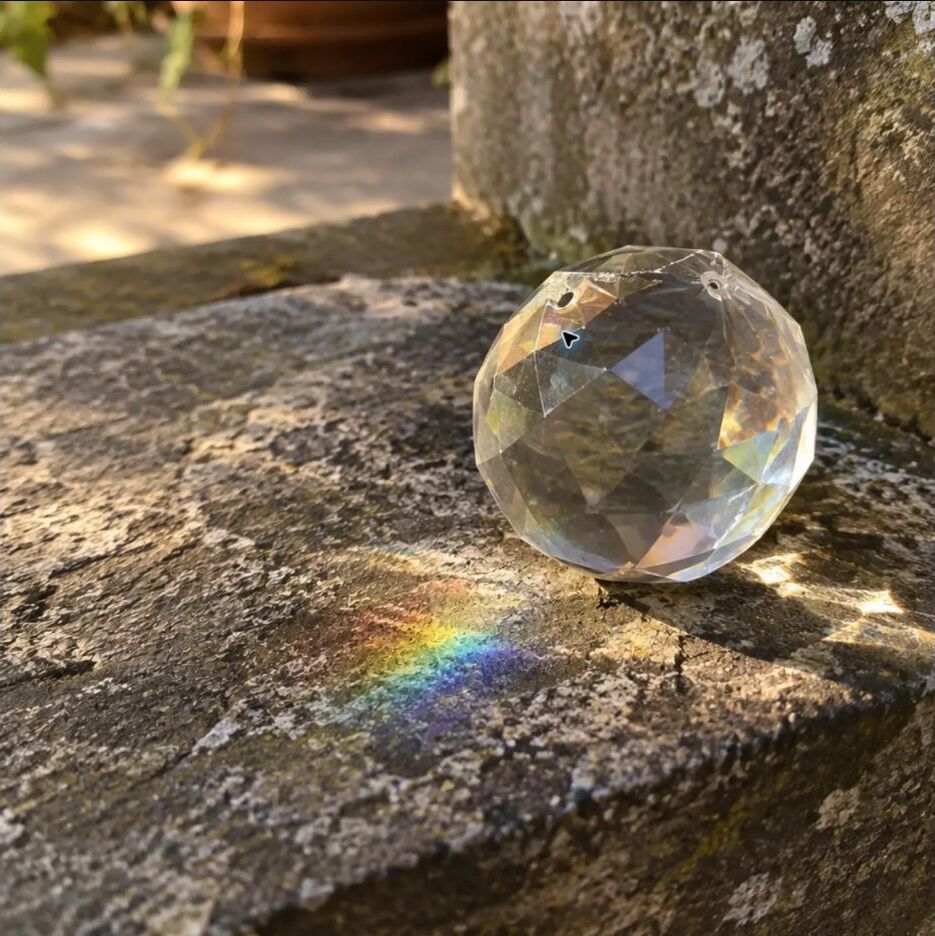 A faceted crystal casting a rainbow on a stone step