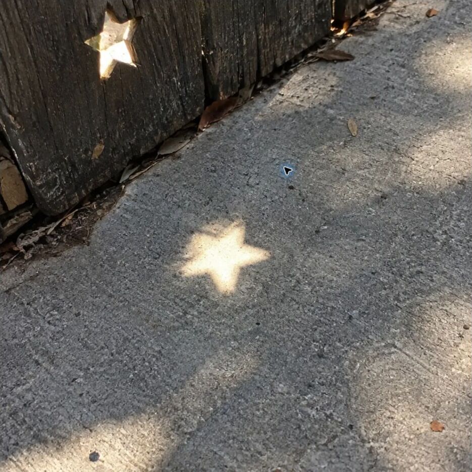A small star-shaped patch of light on a sidewalk