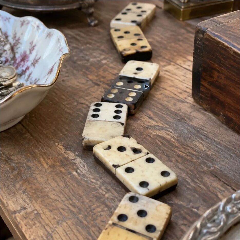 A crooked trail of handmade dominoes on a wooden table
