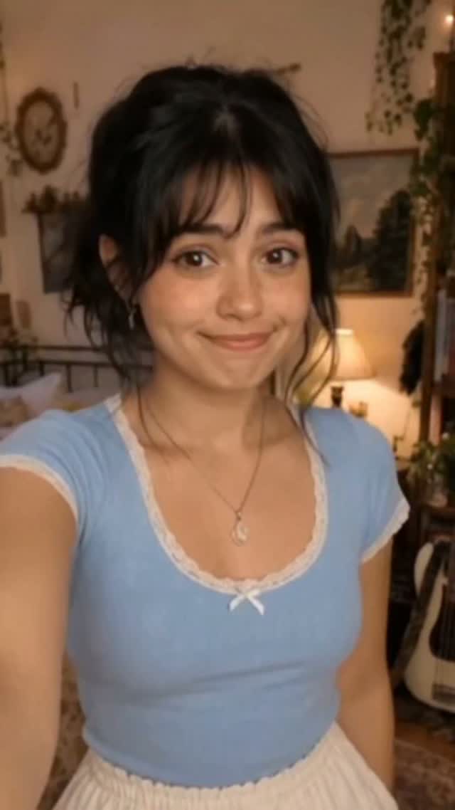A close handheld selfie in a pale blue top