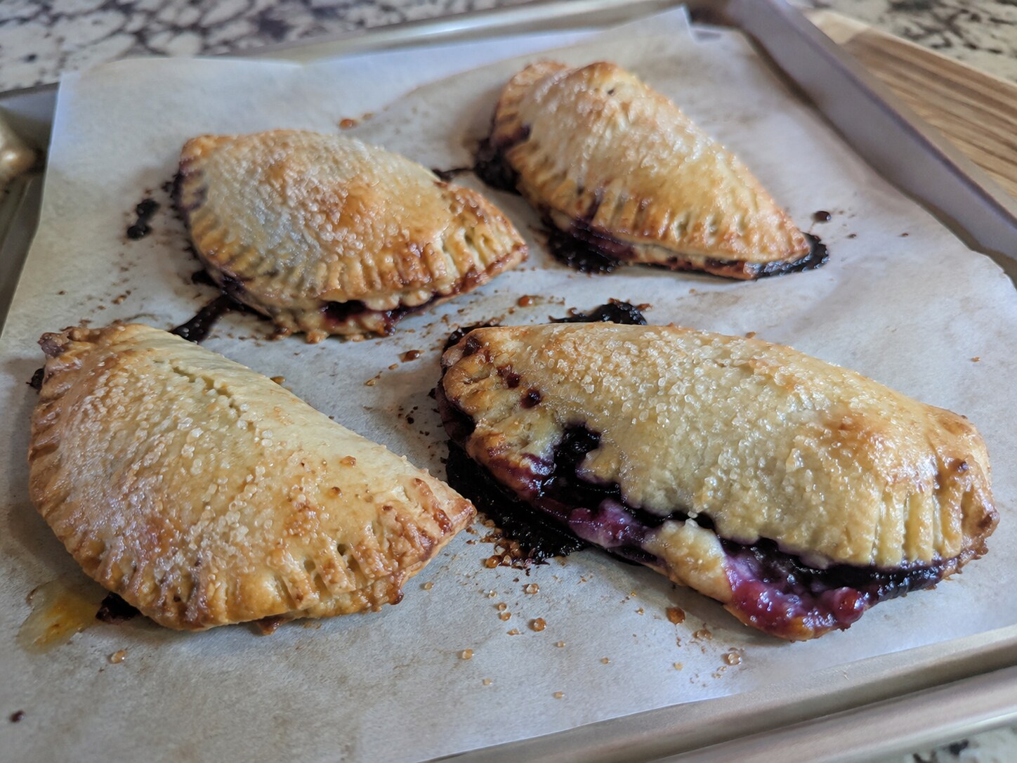 Blueberry hand pies, one leaking a little filling