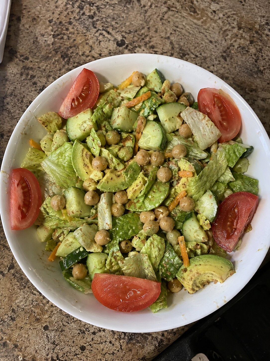 Chopped salad with raw tomato wedges arranged around the rim