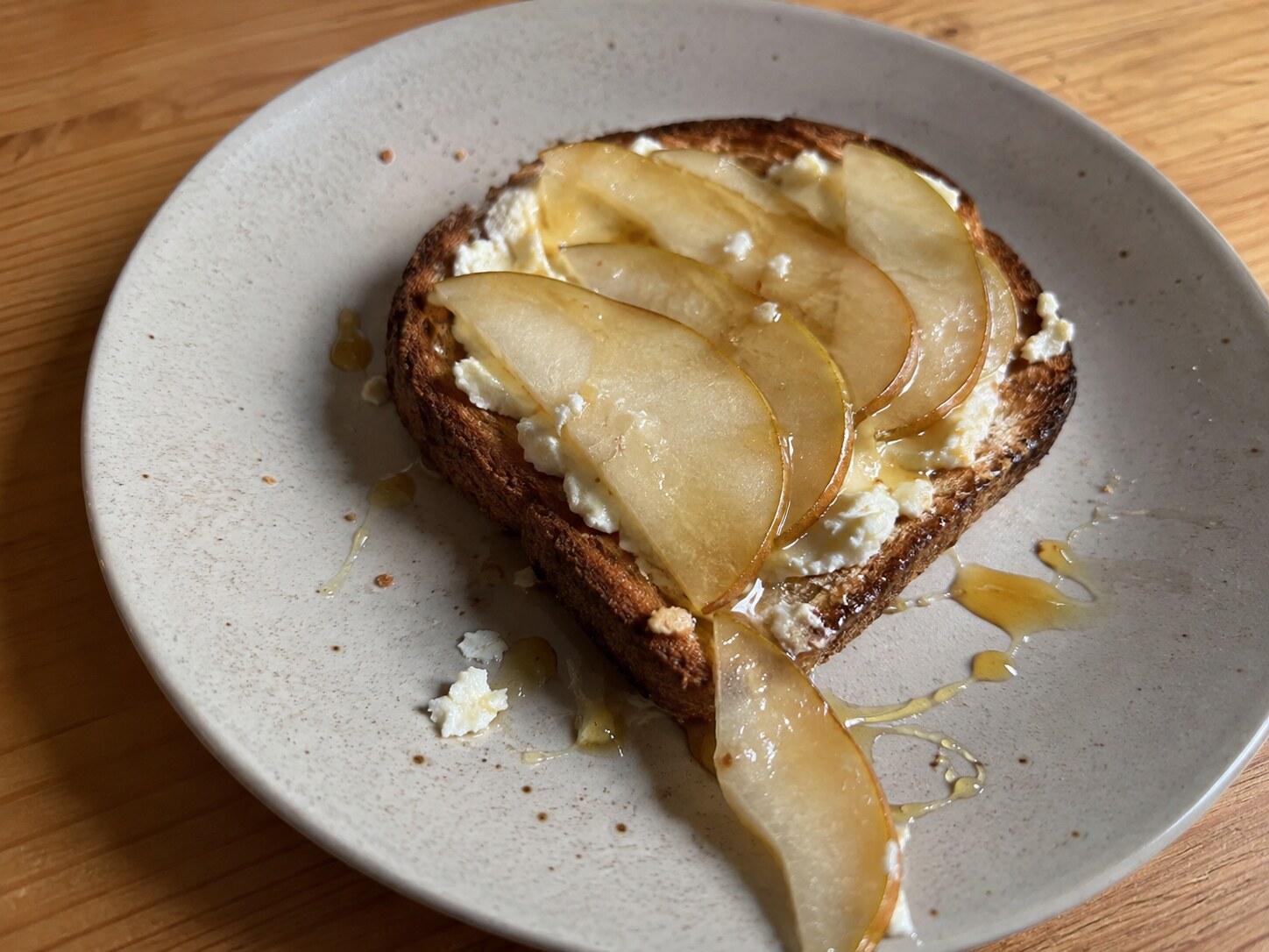 Toast with soft cheese, pear, honey, and pepper